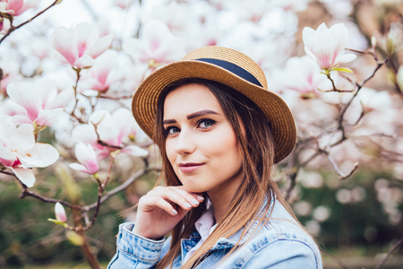 Happy beautiful young woman in spring blossom park.の写真素材