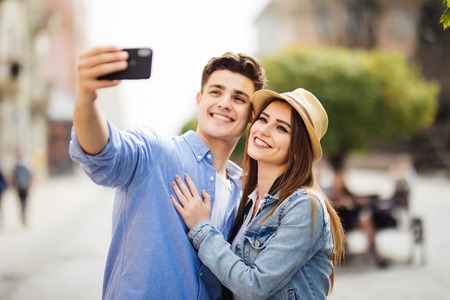 Happy tourists taking selfie on city streetの写真素材