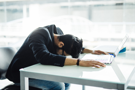 Indian Businessman Sleeping over the laptop in officeの写真素材