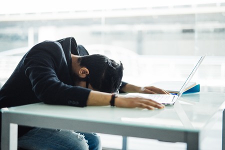 Indian Businessman Sleeping over the laptop in office