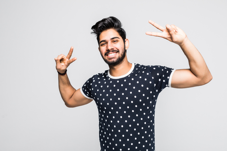 Portrait of happy young man showing victory on white backgroundの写真素材