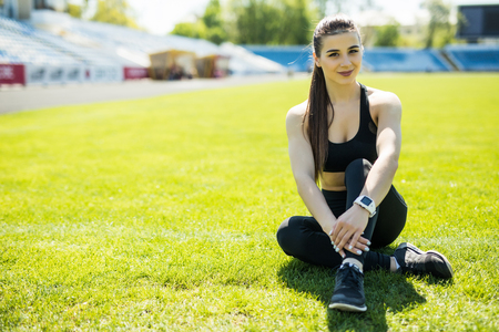 Young woman resting after exercising . Fitness beautiful girl . Female athlete after work out. An athlete resting after training on the grassの写真素材