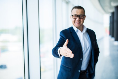 Businessman ready to shake hand in officeの写真素材