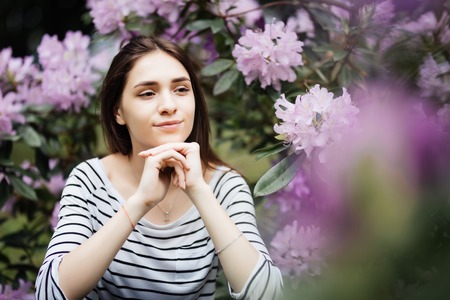 Beautiful young woman on purple background. woman with purple flowersの写真素材