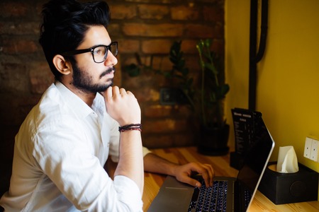 Attractive Asian indian Man in Cafe with laptopの写真素材