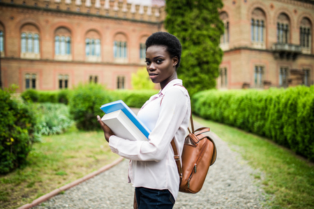 cheerful african college girl outdoors on modern campusの写真素材