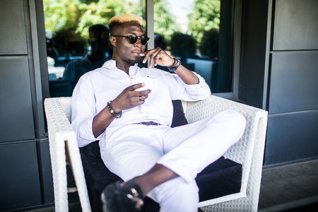 Afro american man drinking a cup of coffee in the cafeの写真素材