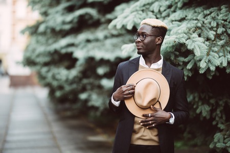 Handsome Afro American man in casual wear and sun glasses walking outdoors in the streetの写真素材