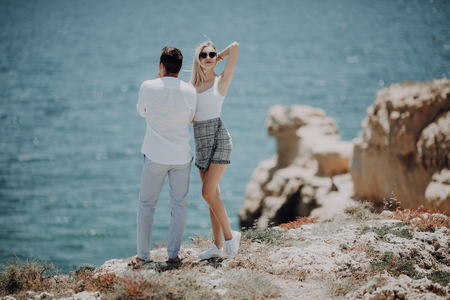 Young beauty couple on the top of the cliff on perfect ocean viewの写真素材