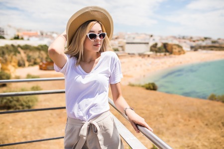 Portrait of young pretty woman with hat on the beachの写真素材