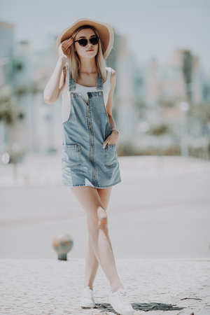 Beautiful young woman wearing dress and walking on the streetの写真素材