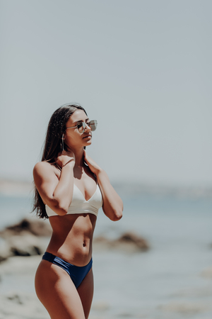 Beautiful woman's body in sexy bikini over beach backgroundの写真素材
