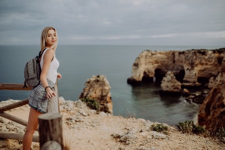 Woman traveler looking at the sea, travel and active lifestyle concept