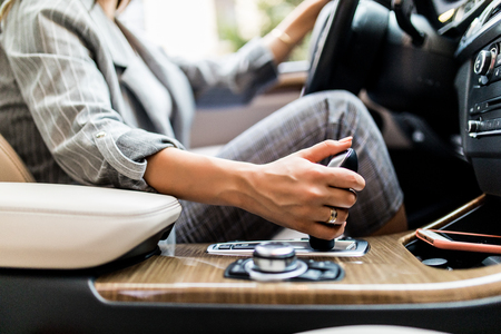 Female hand using a car automatic gear. Woman driving conceptの写真素材