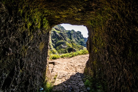 trekking on Madeira island. A route between two peaks Pico Ruivo and Pico do Areeiro. Amazing cliff view with tourist on the edgeの写真素材