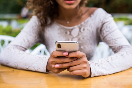 Closeup image of a beautiful woman holding , using and looking at smart phone with feeling happy