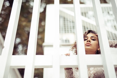 Young latin curly woman standing on the stairsの写真素材