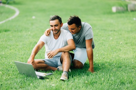 Two Men Working with Computer at Parkの写真素材