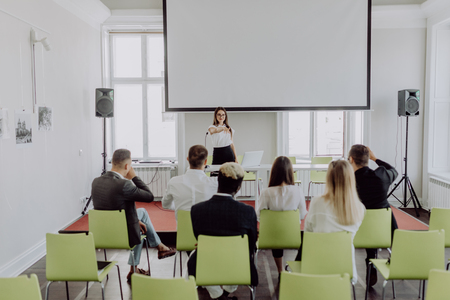 Successful businesswoman giving presentation to business team, female ceo leader coaching teaching on corporate training, woman boss talking planning explaining answering questions at group meetingの写真素材
