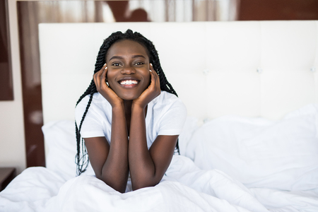 Smiling woman waking up in her bedroomの写真素材