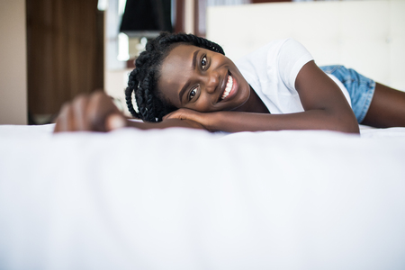 beautiful african american woman lying on bedの写真素材