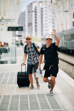 Two man traveler miss train and running after train on platform on railway station.の写真素材