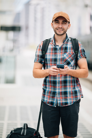 Handsome guy using mobile phone at train stationの写真素材