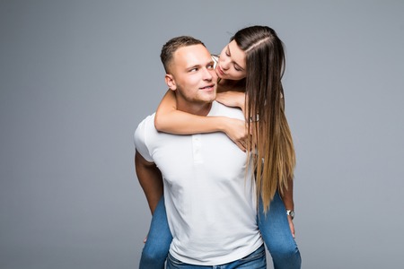 Portrait with copy space empty place of cheerful positive couple, amazed man carrying on back pretty...