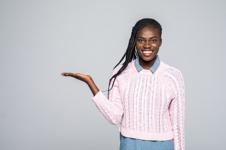 Portrait of shocked woman holding copyspace on palm looking at camera isolated on grey background. Advertisement conceptの写真素材