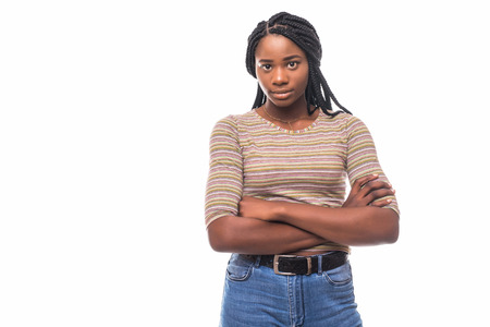 Portrait of a african woman with arms folded standing over gray background and looking away