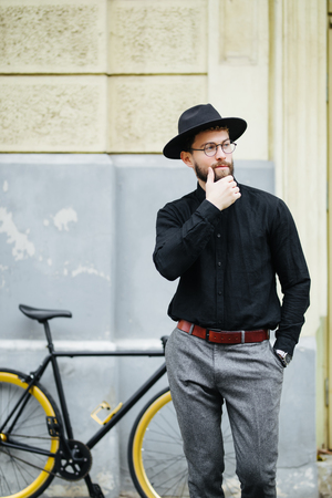 Young hipster man riding fixed gear bike on city streetの写真素材