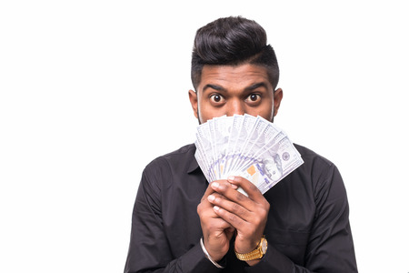 Closeup portrait of bearded hipster young man holding money dollar bills in hand, isolated on white...