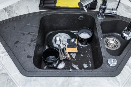 dirty dishes in a kitchen sink at homeの写真素材