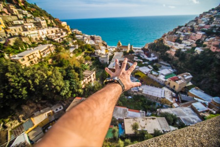 Man hand in front of Positano shore viewのeditorial素材