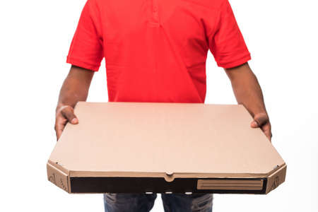 Side view of young delivery man with box. isolated gray backgroundの写真素材