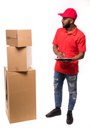 Side view of young delivery man with box. isolated gray backgroundの写真素材