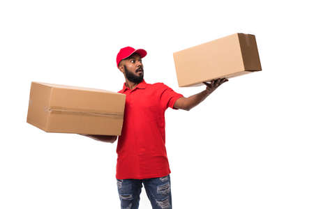Side view of young delivery man with box. isolated gray background