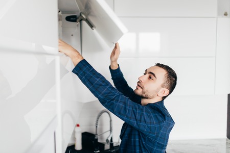 man hand open kitchen cupboard with handle, close upの写真素材