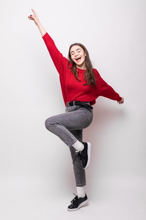 Full length portrait of happy young woman celebrating success over white backgroundの写真素材