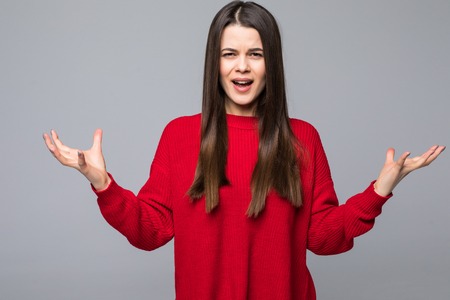 Unsure doubtful puzzled european woman shrugging her shoulders in questioning gesture of uncertainty and having confused clueless lookの写真素材