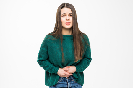 Young pretty woman with stomack pain wearing in green sweater on white backgroundの写真素材