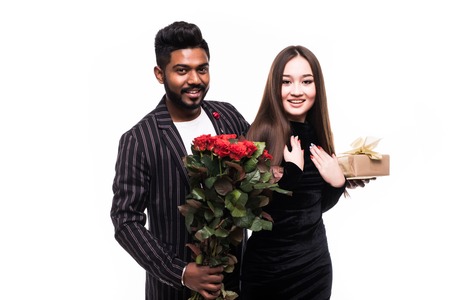 They are as beautiful as you. Full length of indian man giving a bouquet of red roses for his asian...