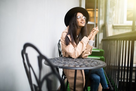 beautiful happy young girl in a hat resting outdoors, woman in cafeの写真素材