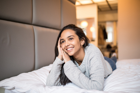 Smiling sexy woman in lingerie relaxing on the bedの写真素材