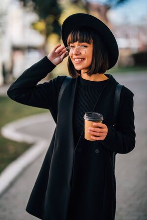 Cheerful woman in the street drinking morning coffeeの写真素材