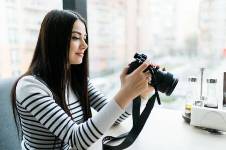 Freelance photographer woman at home office editing photos, empty camera screenの写真素材