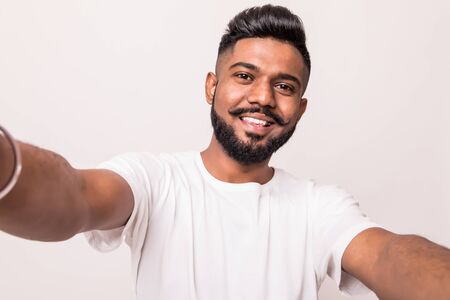 Young indian man taking selfie isolated on white background