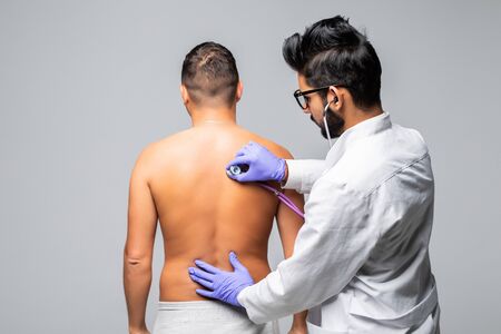 Young Male Doctor Checking Patient With Stethoscope In Hospitalの写真素材