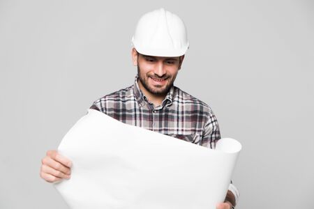 Portrait of male site contractor engineer with hard hat holding blue print paper. Isolated over white background.の写真素材