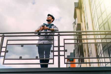 A handsome young businessman standing on the bridge on a sunny day.の写真素材